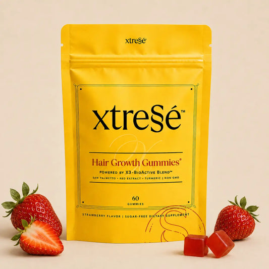 XtreSé Hair Growth Gummies with two red gummy candies resting near the bottom right of the package. For sale at Clover Skin Bar.