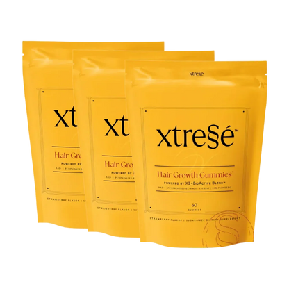 Three yellow stand-up pouches of xtresse Hair Growth Gummies arranged in a fan shape on a white background.