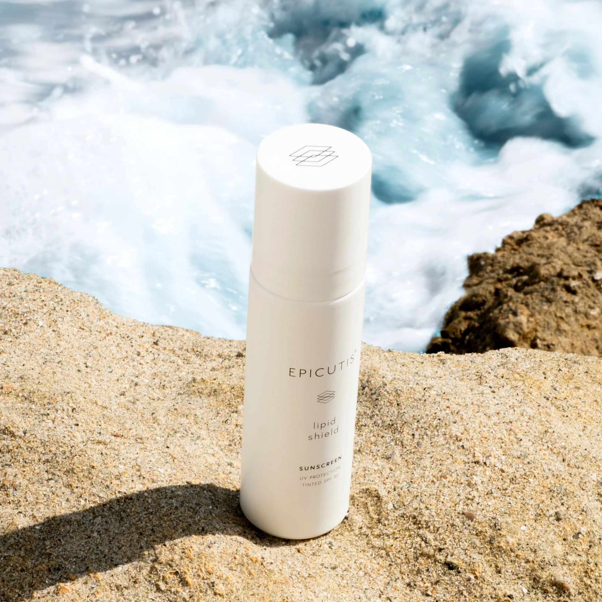 Epicutis Lipid Shield SPF 30 on a rocky surface with ocean waves in the background