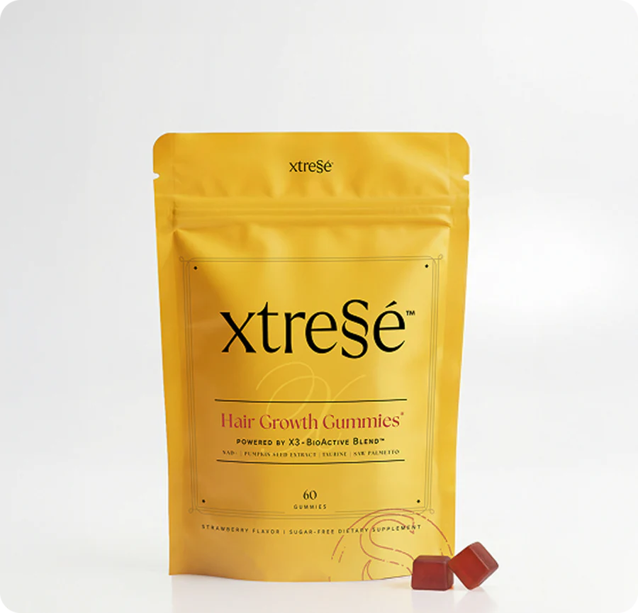 A yellow stand-up pouch of xtreSe Hair Growth Gummies with two small red gummies in front, photographed on a clean white background. 